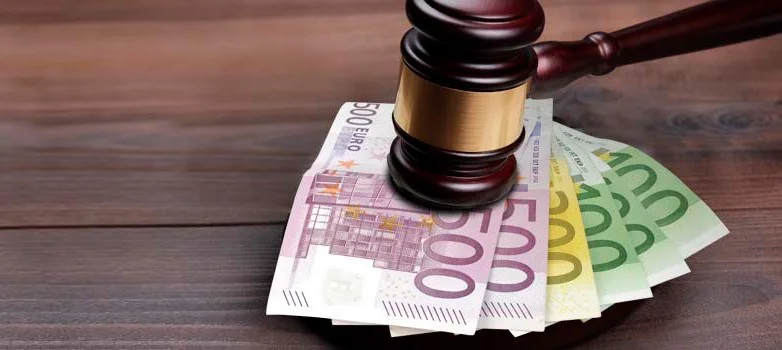 Martelletto del giudice su banconote - simbolo delle sanzioni penali e pecuniarie per violazioni radon
