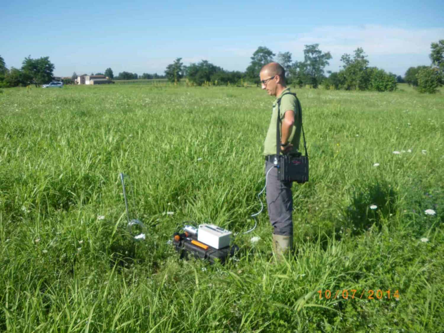 Technician with probe and active monitor on building land in summer